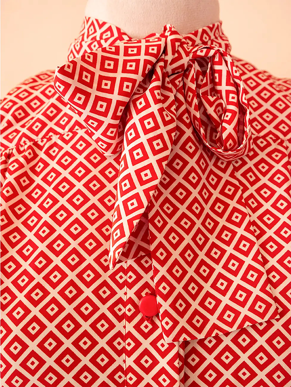 70s vintage Nina Ricci red dress with geometric print, puff sleeves, front buttons, and self-tie neck detail — elegant and easy daywear silhouette.
