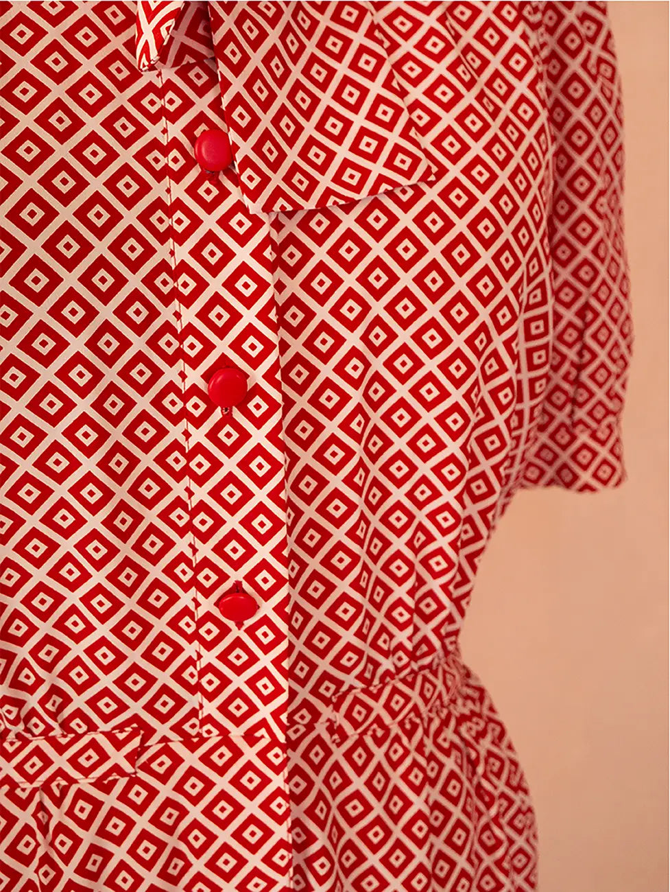 70s vintage Nina Ricci red dress with geometric print, puff sleeves, front buttons, and self-tie neck detail — elegant and easy daywear silhouette.