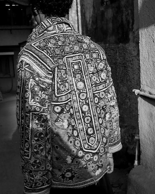 One-of-a-kind jacket handcrafted from traditional Rabari cholas panelled together, lined with a vintage silk sari, featuring a boxy fit with dropped shoulders.