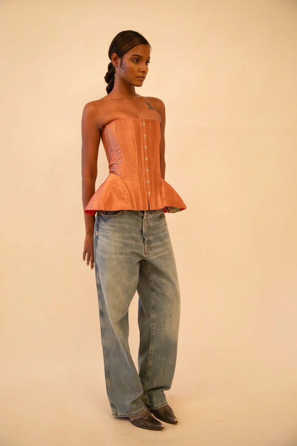 Bell corset handcrafted from a vintage rose gold silk sari, featuring front closure and adjustable lace-up back, designed for a structured fit and celebrating mindful craftsmanship.