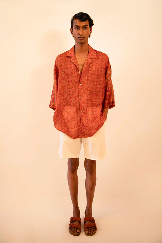 Oversized orange printed silk shirt handcrafted from a vintage sari, featuring a relaxed fit, 3/4 sleeves, soft texture, and playful button details, celebrating comfort, craft, and thoughtful design.