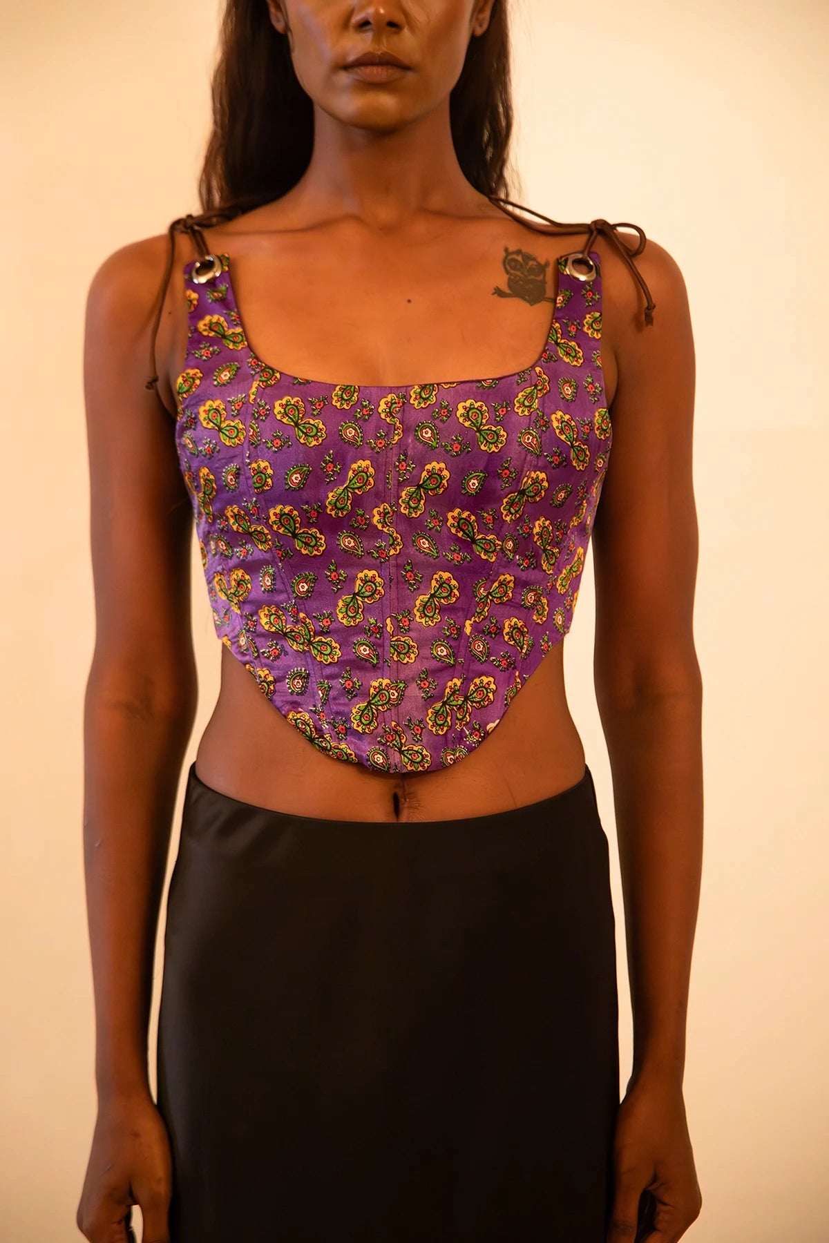 Purple printed silk corset with adjustable straps, handcrafted from a vintage sari, featuring intricate motifs, structured fit, smocking detail, and metal back zipper.