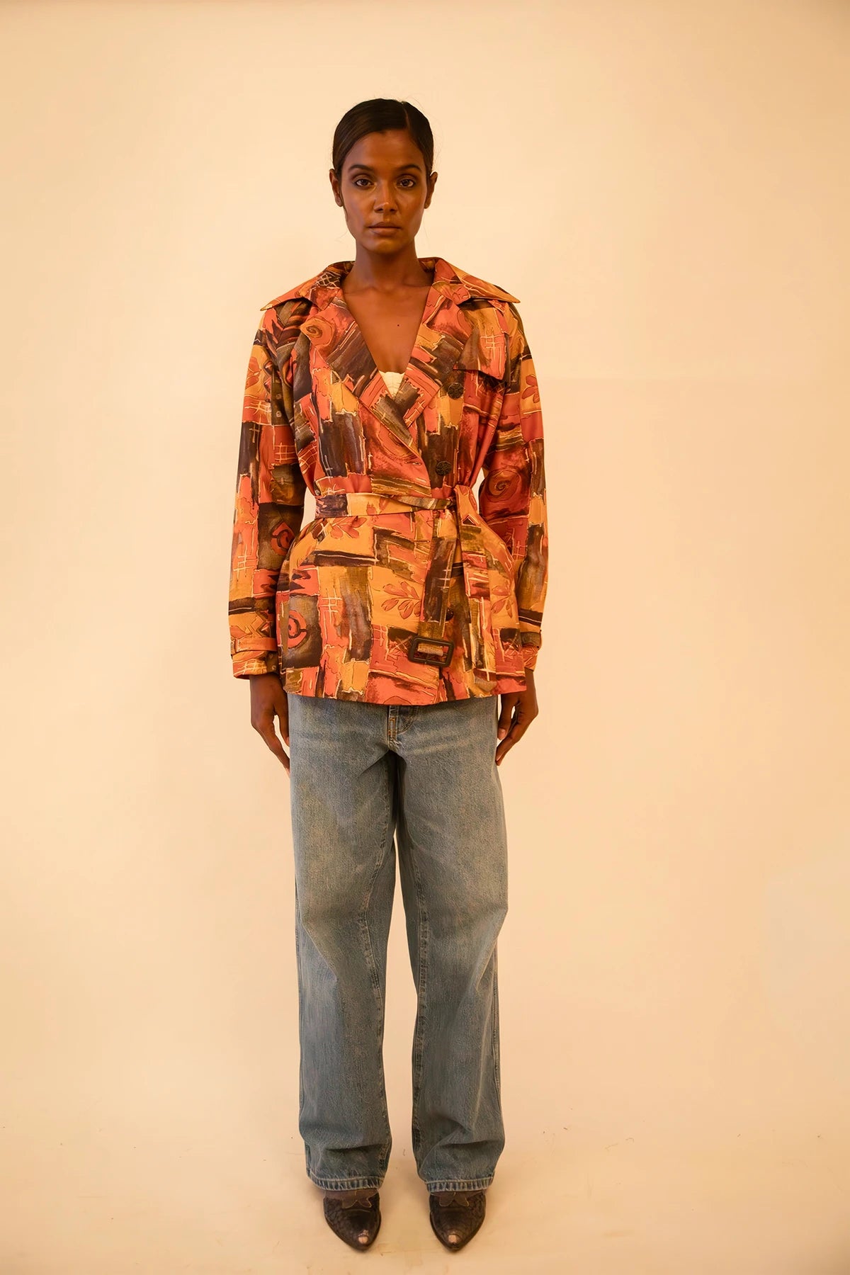 Cropped trench coat crafted from upcycled abstract print silk, featuring a relaxed fit and lightweight structure.