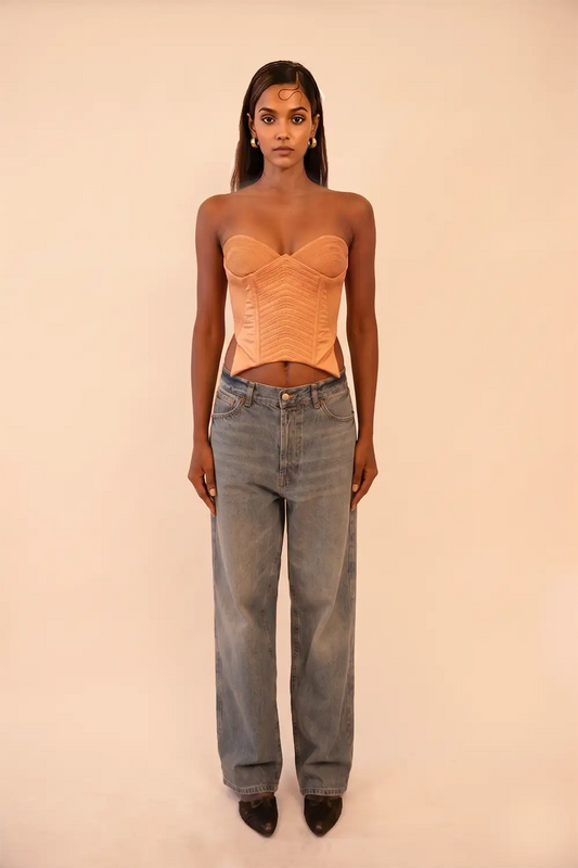 VANA is our one-of-a-kind silk corset, handcrafted in-house using a vintage silk saree. The structured silhouette features intricate hand-done cording details, allowing for a cinched yet refined wear that beautifully adds depth and dimension to the body. Vana is a quiet reflection of meticulous craftsmanship and intentional design.